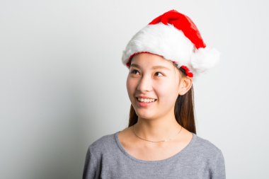 Genç Asyalı kadın üzerinde beyaz izole Noel şapka ile.