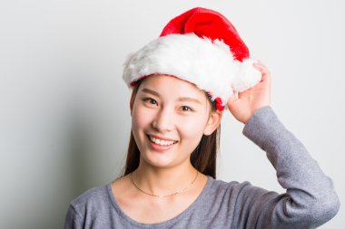 Genç Asyalı kadın üzerinde beyaz izole Noel şapka ile.
