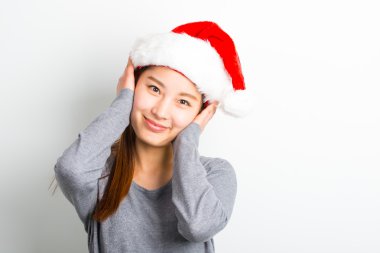 Genç Asyalı kadın üzerinde beyaz izole Noel şapka ile.
