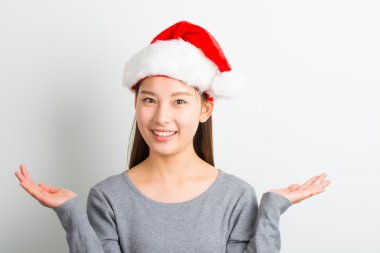 Genç Asyalı kadın üzerinde beyaz izole Noel şapka ile.