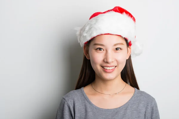 Jovem mulher asiática com chapéu de Natal isolado no branco . — Fotografia de Stock