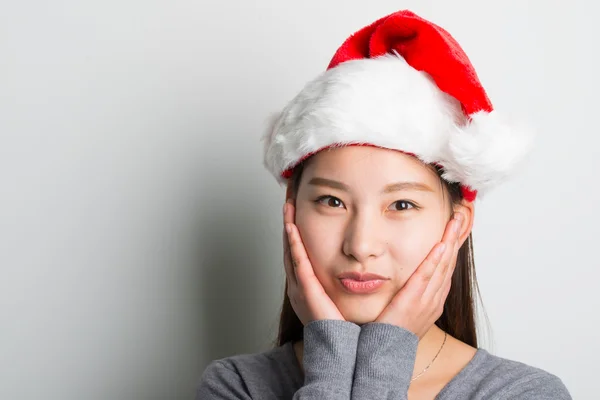 Jovem mulher asiática com chapéu de Natal isolado no branco . — Fotografia de Stock