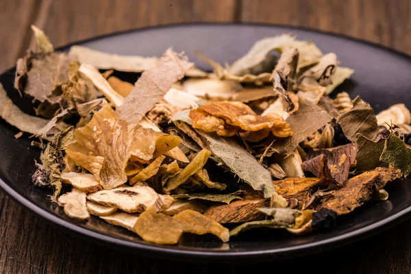 Chinese traditional herbs in the black plate. — Stock Photo, Image
