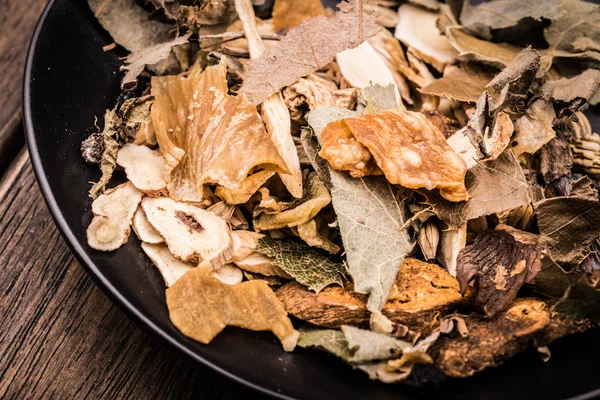 Chinese traditional herbs in the black plate. — Stock Photo, Image