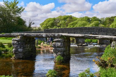 Dartmoor, Devon, West Country, İngiltere 'deki Postbridge' deki Doğu Dart Nehri üzerindeki ortaçağ alkışlayıcı köprüsü.