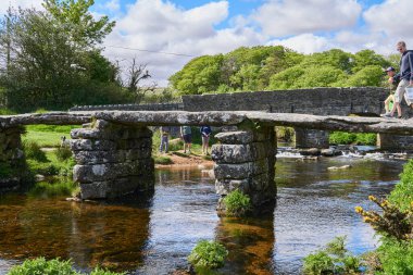 Dartmoor, Devon, West Country, İngiltere 'deki Postbridge' deki Doğu Dart Nehri üzerindeki ortaçağ alkışlayıcı köprüsü.