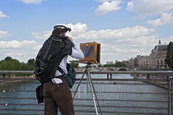 Fotograf s starý deskový fotoaparát na Seinu mostě Passerelle Solferino v Paříži — Stock fotografie