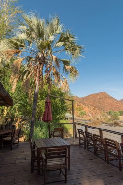 EPUPA, NAMIBIA-ARALIK 19, 2020: Kunene Nehri manzaralı ahşap teras, Namibya