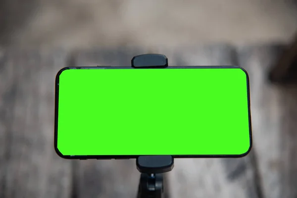 Close up smartphone with green screen background.