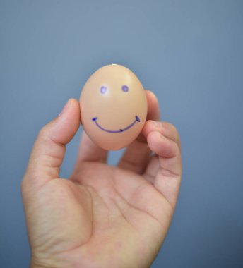 Gri arka planda yumurta gülümseme işareti.