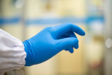 Laboratuvarda mavi eldiven denemesi yapan bir el bilimcisi..