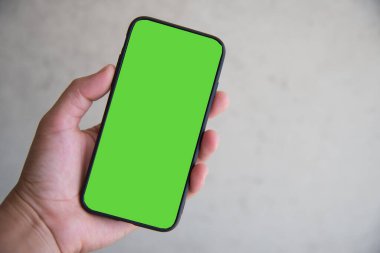 Hand with smartphone green screen background.