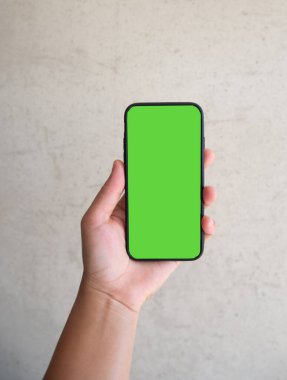 Hand with smartphone green screen background.
