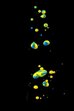 Uzayda renkler. Kabarcıklar yükseliyor. Suyun altında renkli boya. Sanatsal soyut tasarım siyah arkaplanda izole edildi.