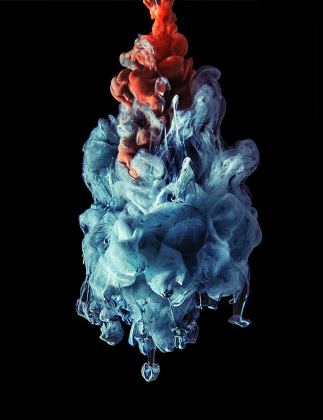 Colorful ink under water. Artistic abstract design isolated on black background.
