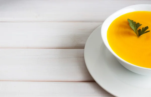 Sopa de abóbora em uma mesa de madeira — Fotografia de Stock