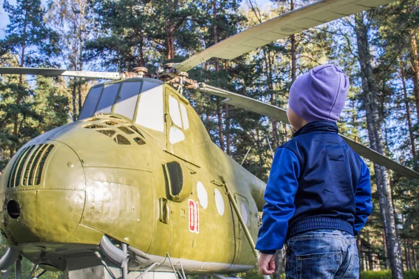 Niño parado frente a un solo helicóptero y soñando con volar — Foto de Stock