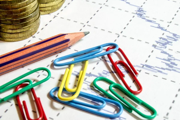 Financiar o cálculo de negócios com gráfico, clipes de cores, lápis e moedas — Fotografia de Stock