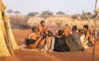 San bushmen ailesi insanlara Namibya 'daki Kalahari çölünün bir köyünde nasıl yaşadıklarını gösteriyor..