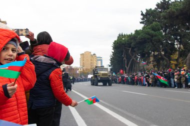 Çocuklar ellerinde bayraklarla askeri geçit törenine geliyorlar. Azerbaycan ve Türkiye kardeştir. Bakü-Azerbaycan: 10 Aralık