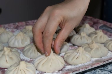 Gürcistan usulü khinkali köftesi ve et. El khinkali 'yi kuyruğundan tutar..