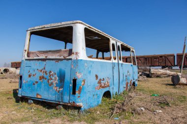 Terk edilmiş eski bir otobüs. Paslı eski mavi bir minibüs. SSCB yapımı..