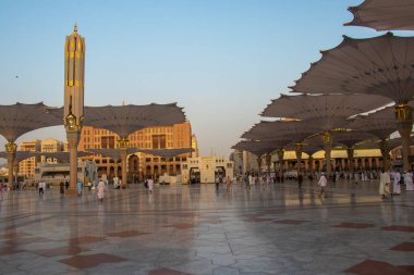 Madinah al Munawwarah. Nabawi Camii 'nin dış görünüşü. Cami avlusunda yürüyen Müslüman hacılar