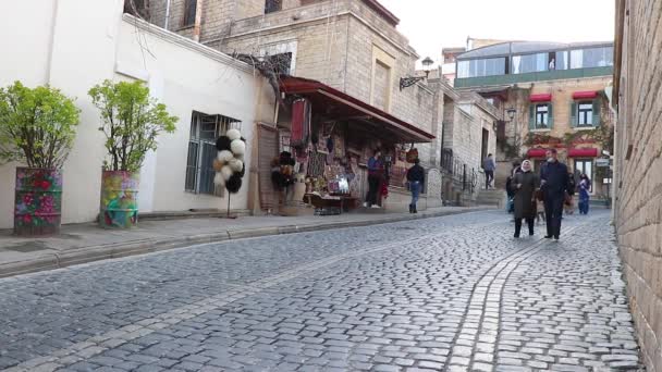 Bakoe - Azerbeidzjan. Mensen en gezinnen wandelen in de straat van Baku in het weekend. Cobblestone straat van Icherisheher — Stockvideo