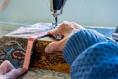 Arap Müslüman kadın, bant ile dikiş dikiyor ve boyunu ölçüyor.