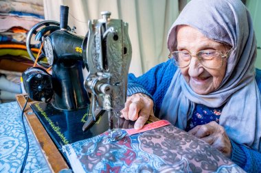 Arap Müslüman kadın, bant ile dikiş dikiyor ve boyunu ölçüyor.