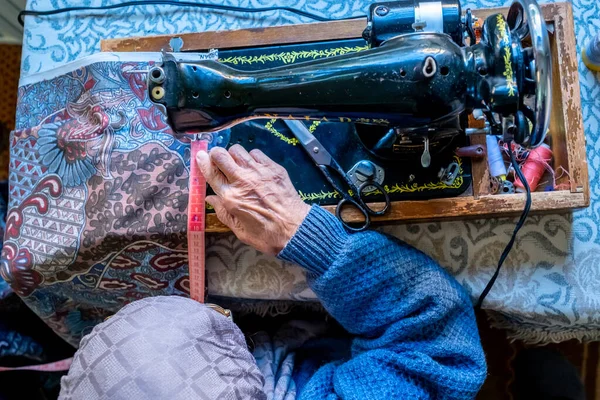 アラビア語のイスラム教徒の女性の縫製と彼女のテープで長さを測定 — ストック写真