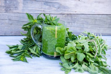 Maydanoz ve ıspanakla çevrili yeşil smoothie.