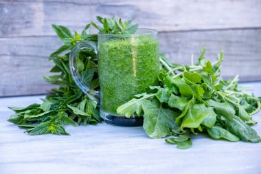 Maydanoz ve ıspanakla çevrili yeşil smoothie.