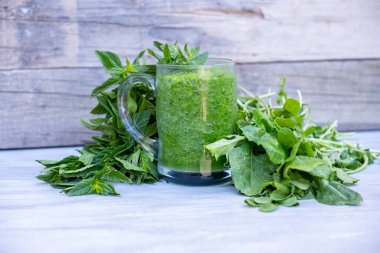 Maydanoz ve ıspanakla çevrili yeşil smoothie.