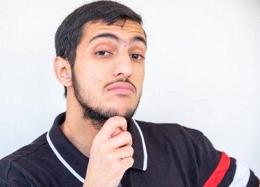 Arap adam ayakta duruyor ve fikirleri düşünüyor.