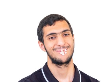 Arap müslüman çocuğun ağzında çiçek var.