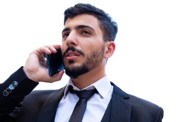 İş adamı, iş görüşmelerini sürdürmek ve zamana göre iş güncellemelerini takip etmek için bir çağrı veya video aramasında cep telefonu kullanarak tartışır ve işi tartışır.