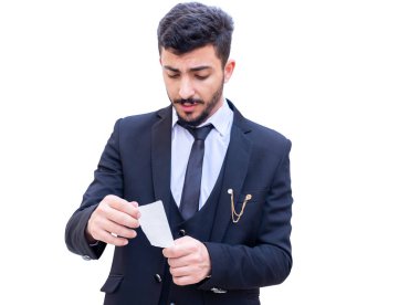 Arap adam elinde bir fatura tutuyor ve süpermarketten aldığı eşyaların toplamını kontrol ediyor.