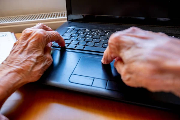 Old woman using laptop for working and communicating