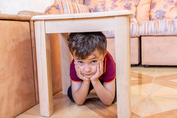 Masanın altında saklanan Arap Müslüman çocuk.