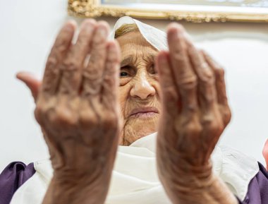 Yaşlı Müslüman kadın Tanrı 'ya onu kutsaması ve ona güç vermesi için dua ediyor.