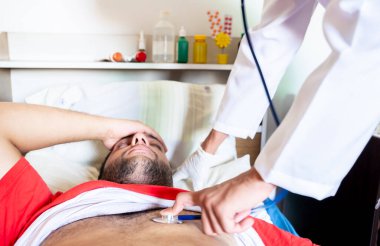 Arap adam hasta ve doktor tarafından kontrol ediliyor.