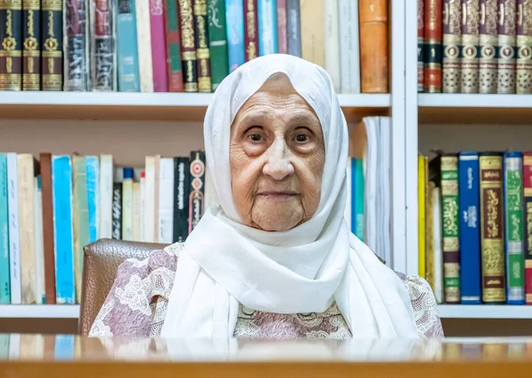 Arabic muslim woman supervising library and asking people to keep quiet