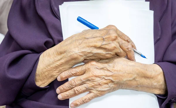 Old muslim woman signing some documents