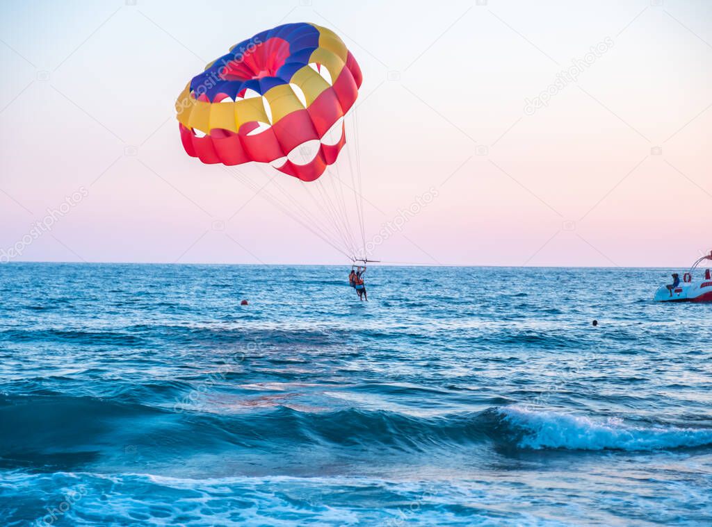 Boat dragging couples with clourfull parachute