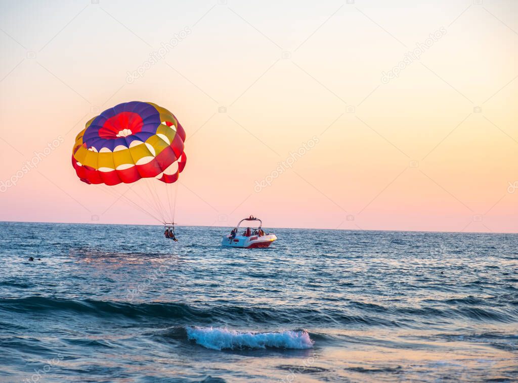 Boat dragging couples with clourfull parachute