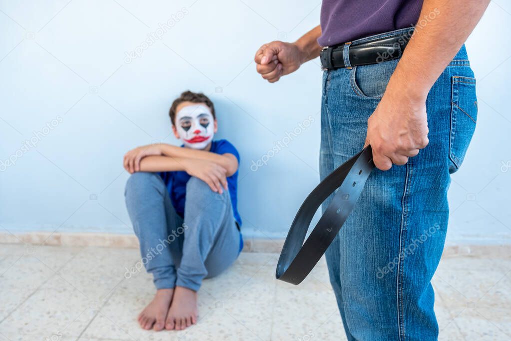 Boy watching his parents fighting and his father holding a belt