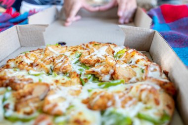 Mutlu Arap oğlanlar parkta pizzanın tadını çıkarıyorlar.