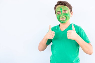 Çocuk ellerini ve yüzünü kullanarak renklerle oynuyor.