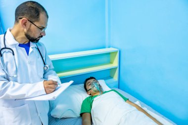 Doktor hastasını kontrol ediyor ve sonuçlarını yazıyor.